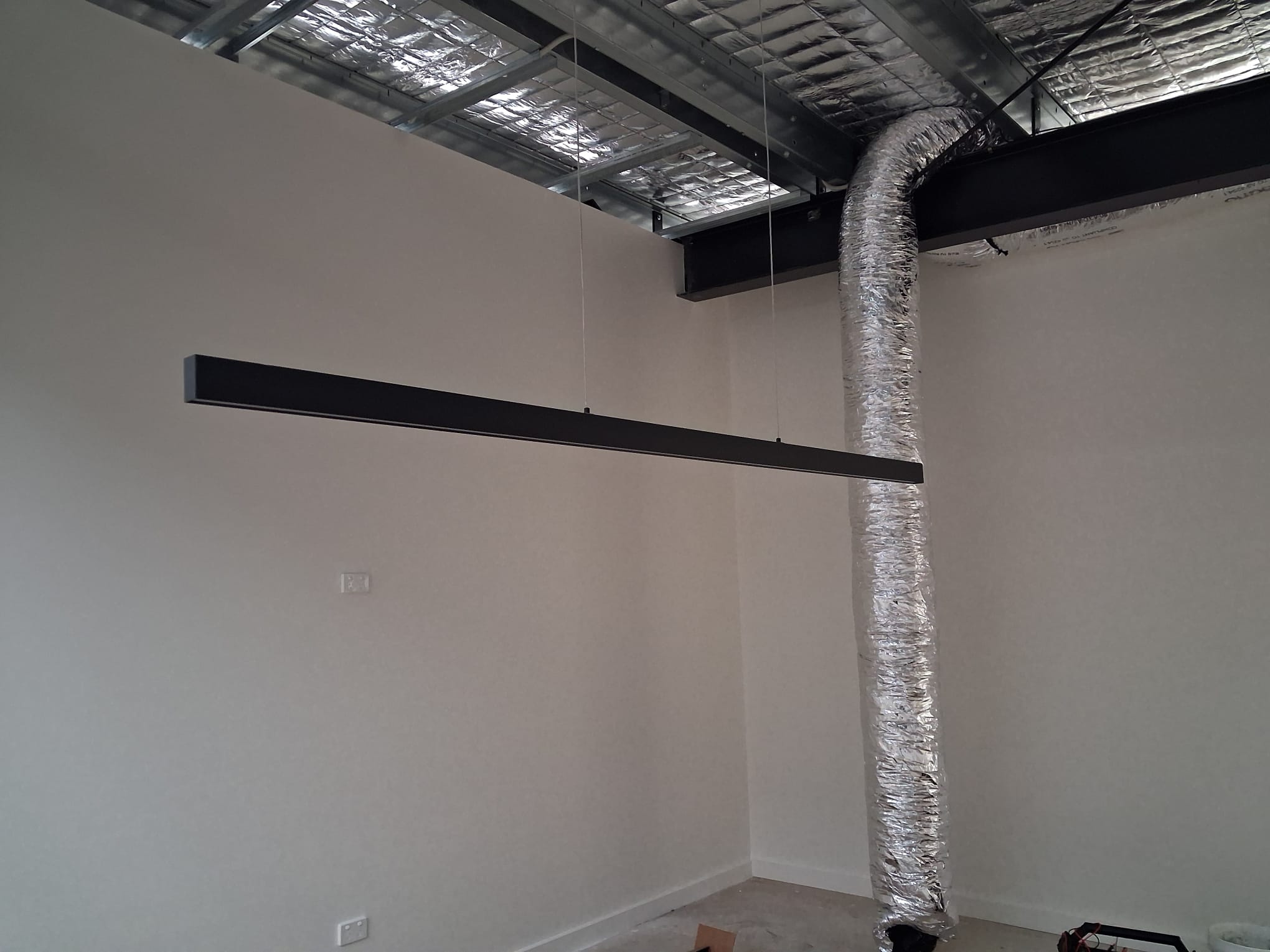 Considered details — suspended linear lighting and exposed services in the upstairs meeting space.